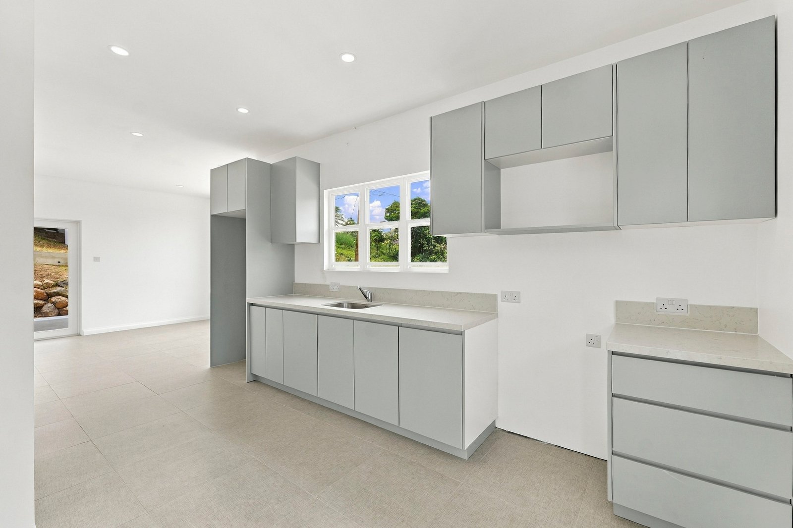 Allspice design, Lot 128: grey kitchen cabinetry with white counters and a window over the sink.