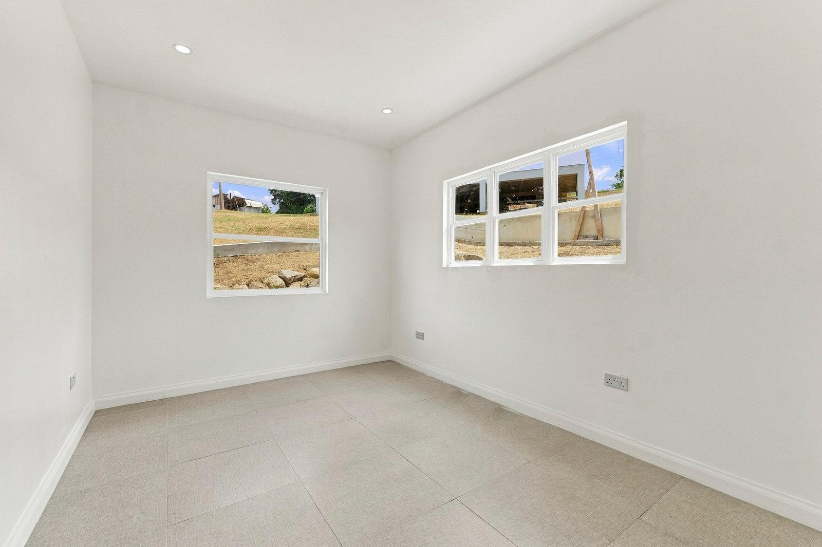 Allspice design, Lot 128: unfurnished room with two windows on adjoining walls.