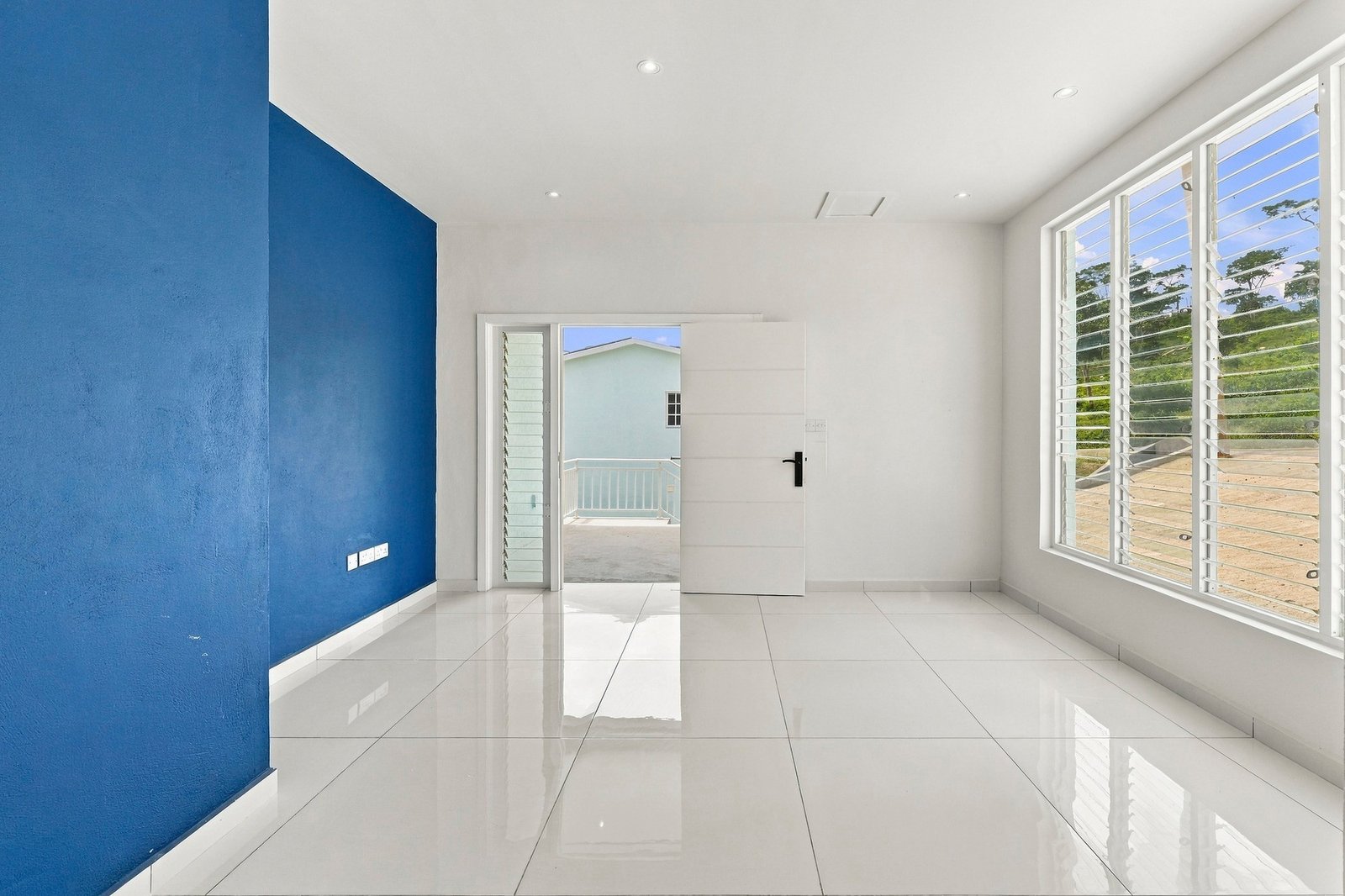 Bayleaf design, Lot 123: living area with a blue feature wall, large window and porch doorway.
