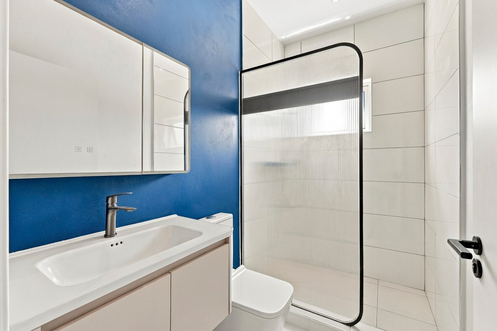 Bayleaf design, Lot 123: bathroom with a white vanity, blue wall and black-framed shower screen.