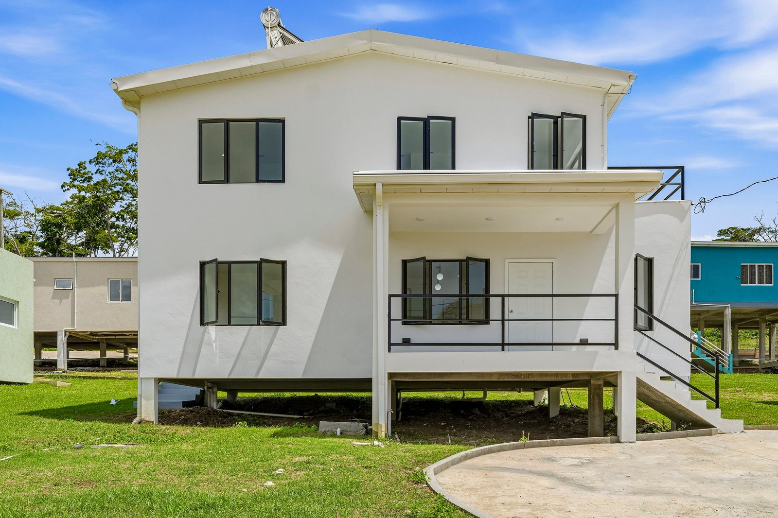 Front exterior of the Clove home on Lot 116, showing its white facade, entrance porch, steps and upper level.