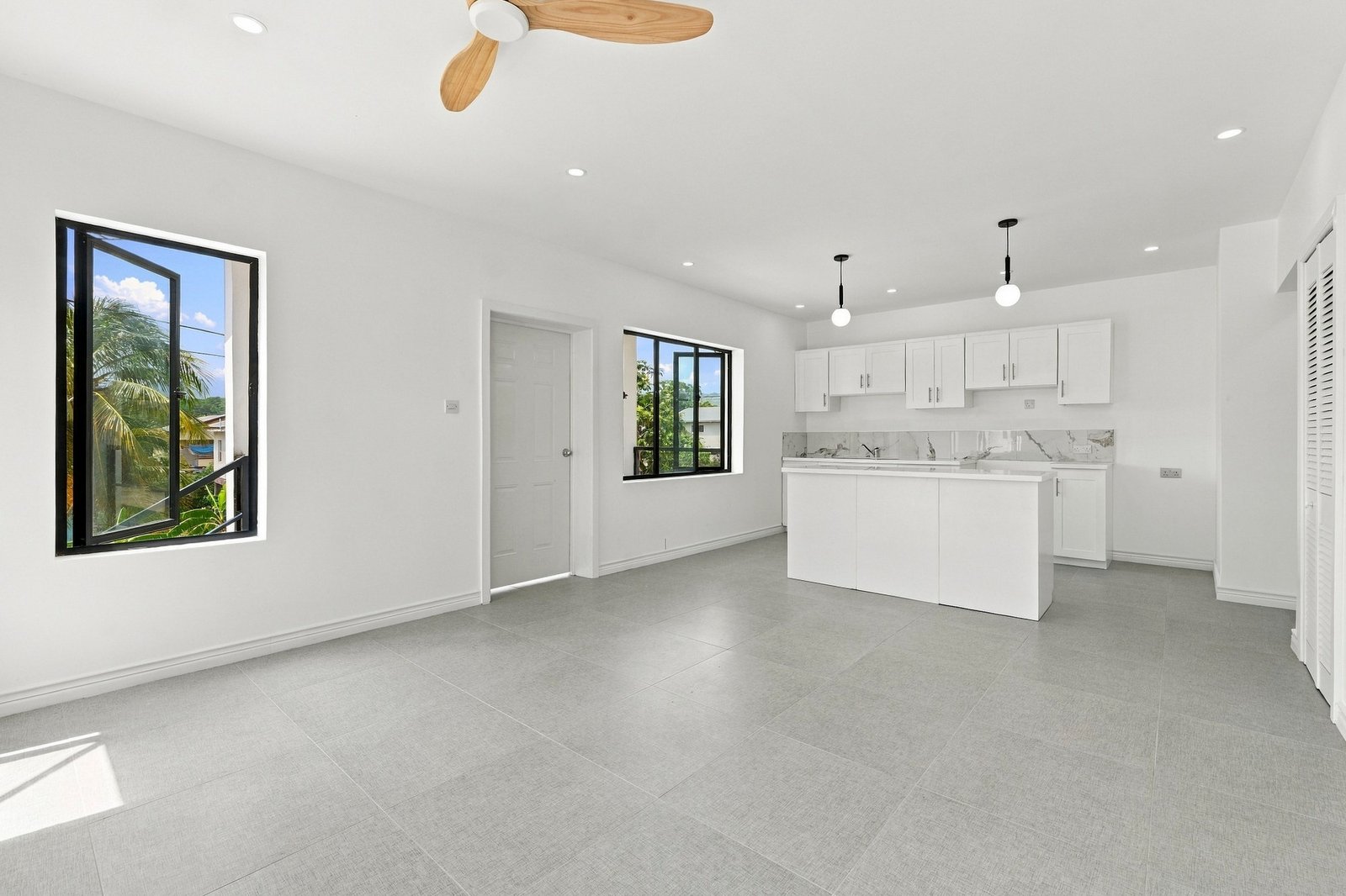 Open-plan living and dining space in the Clove home on Lot 116, looking toward the white kitchen and island.
