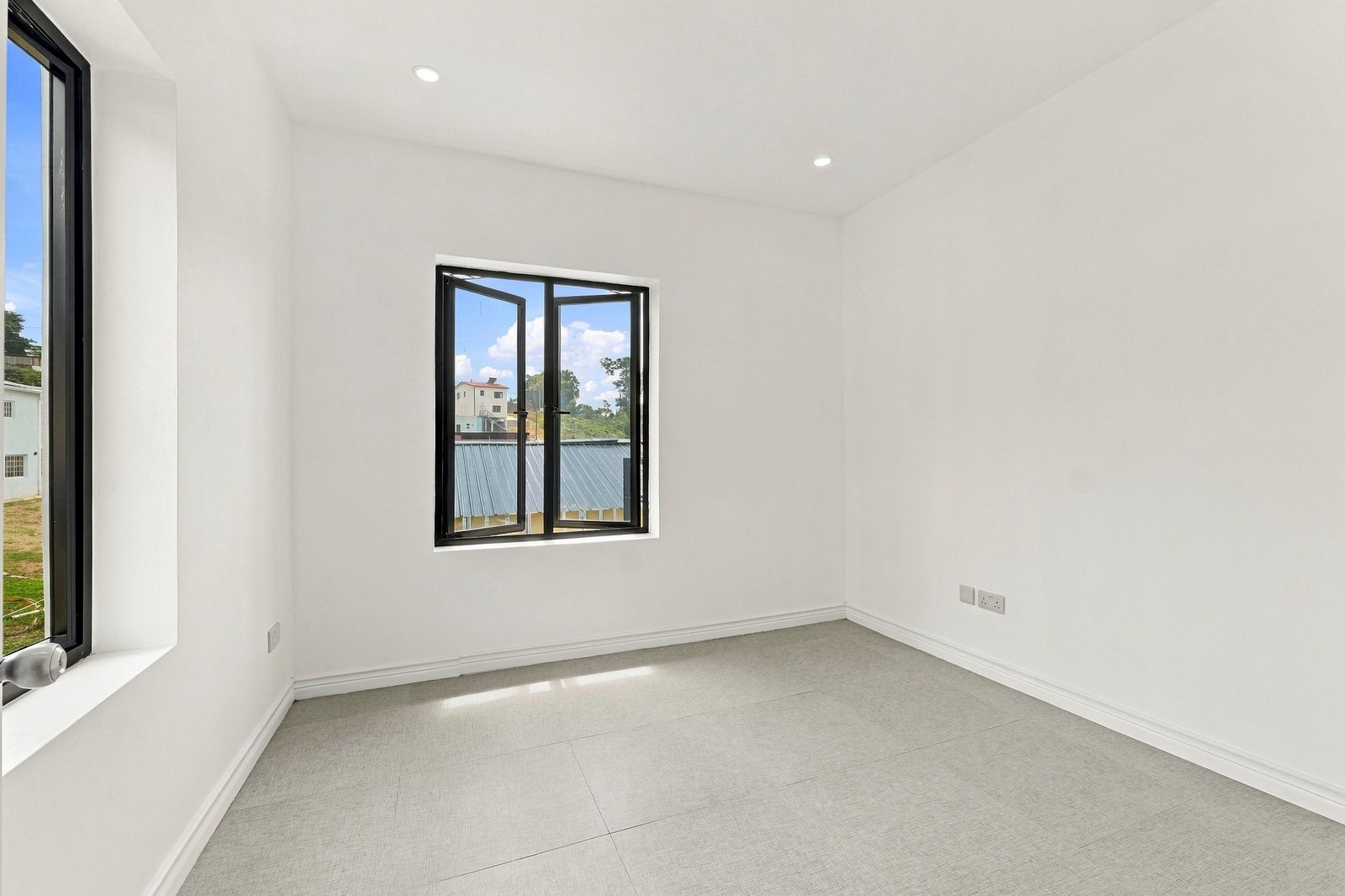 Unfurnished room in the Clove home on Lot 116, with a black-framed window and grey tiled floor.
