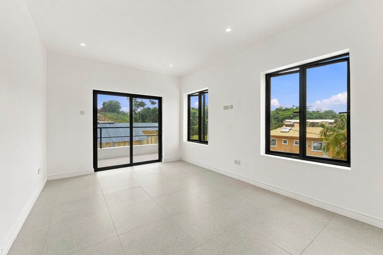 Bright room in the Clove home on Lot 116, with windows on two walls and a sliding glass door to a balcony.