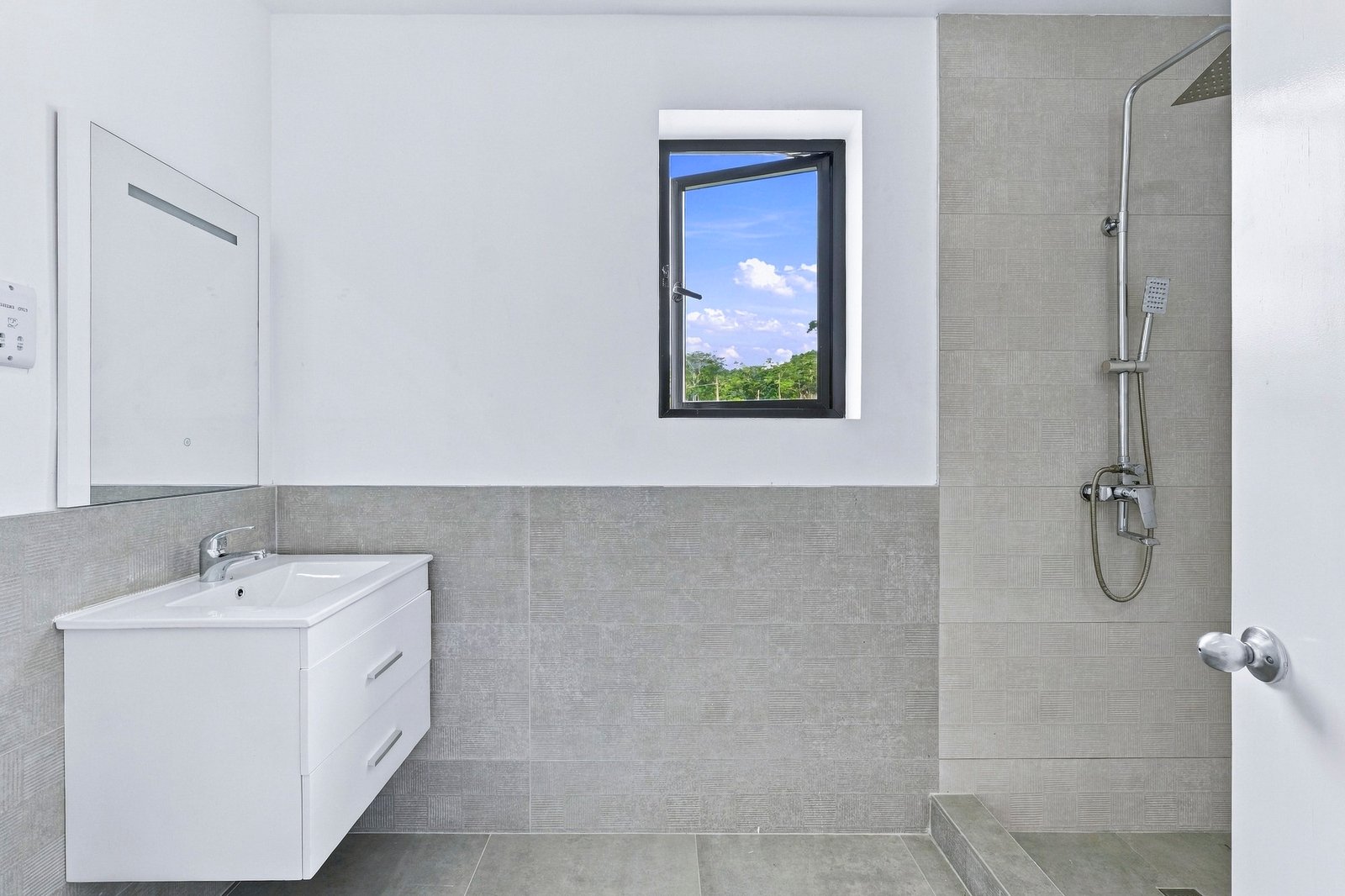 Bathroom in the Clove home on Lot 116, with a floating white vanity, textured grey tiles and a shower.