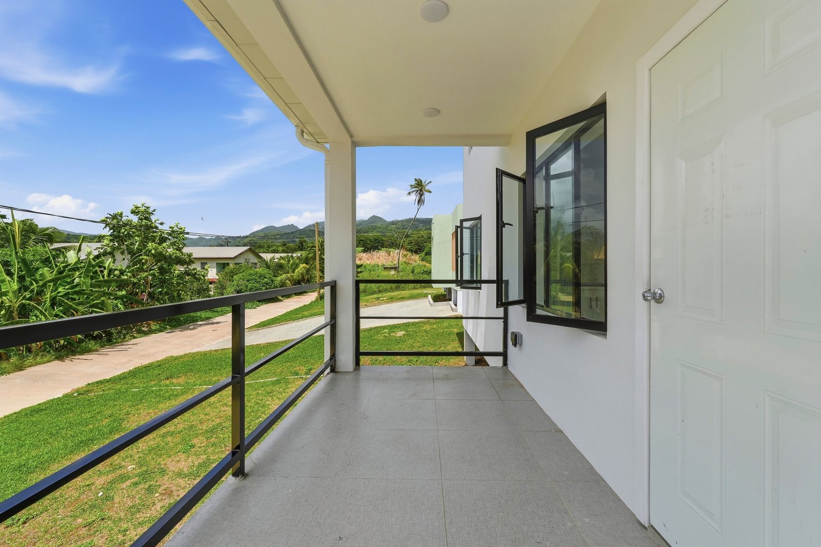 Covered entrance porch of the Clove home on Lot 116, with white columns, black railings and a front door.