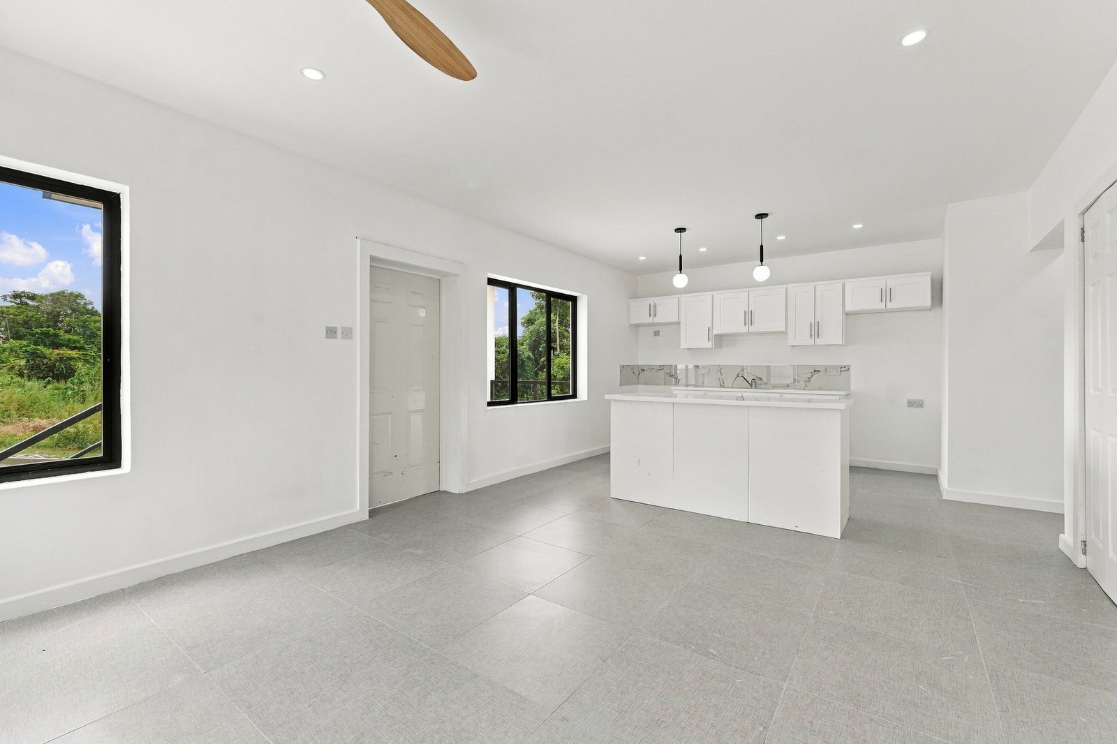 Open-plan living and dining space in the Clove home on Lot 130, looking toward the white kitchen and island.