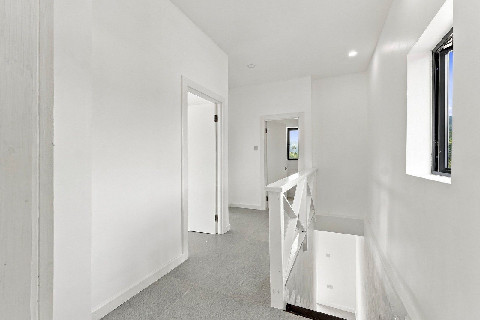 Upper landing in the Clove home on Lot 130, with a stair opening, white rail and adjoining doorways.