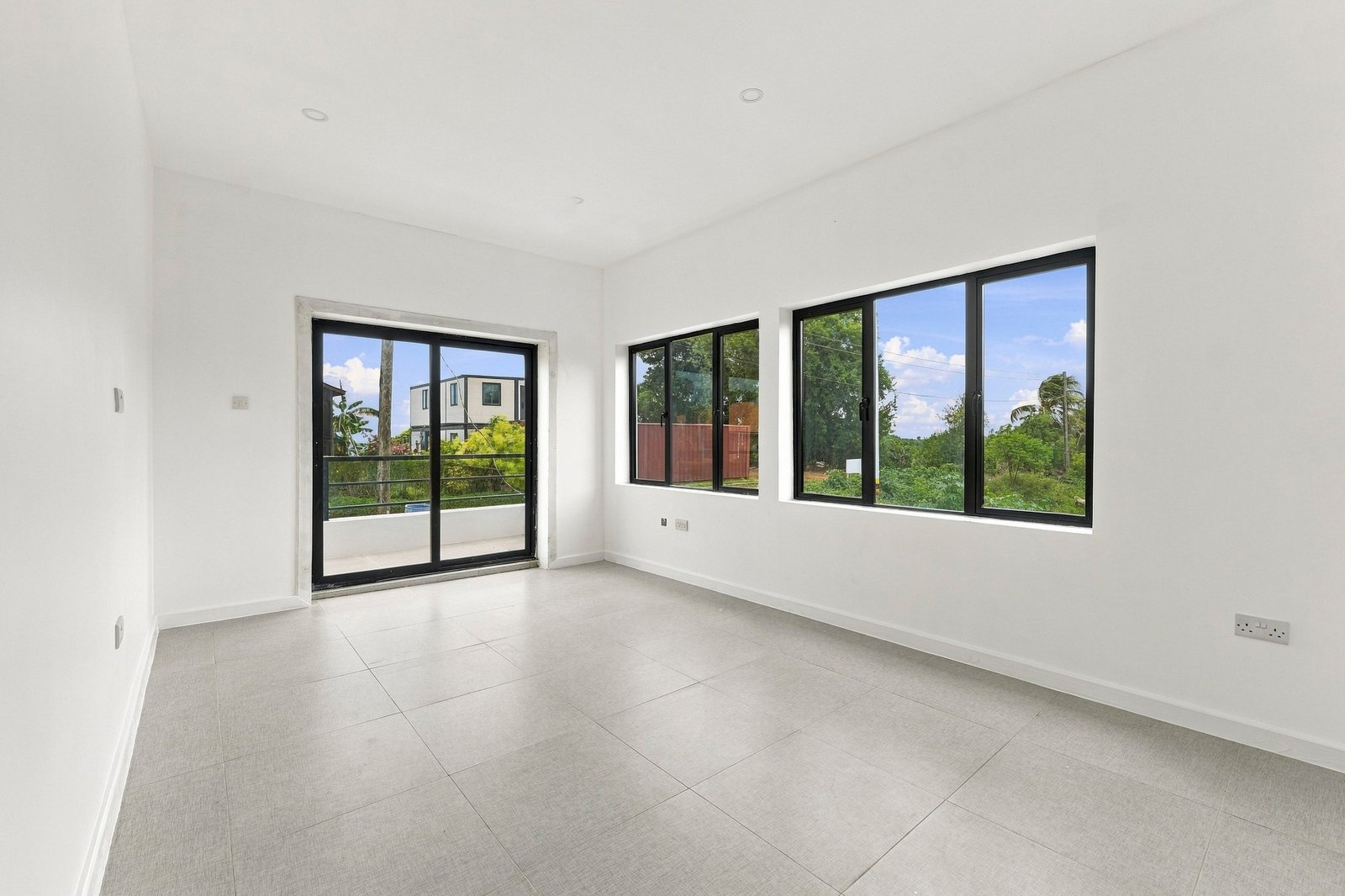 Bright room in the Clove home on Lot 130, with large windows and a sliding glass door to a balcony.