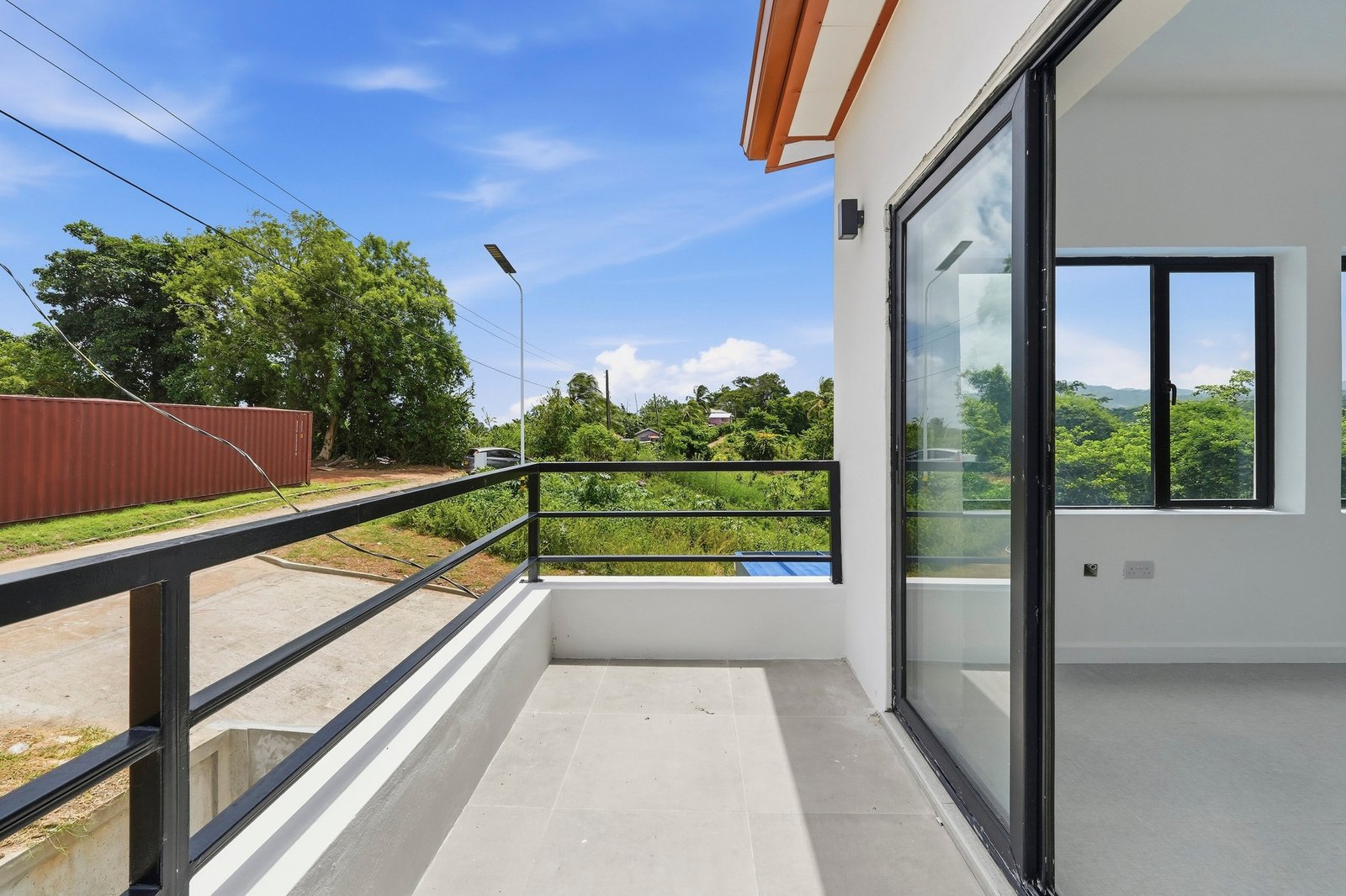 Upper balcony of the Clove home on Lot 130, with black railings and a sliding glass door.