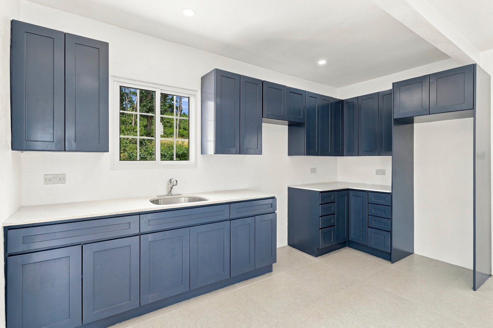 Coconut design, Lot 113: blue kitchen cabinets, white counters and a window over the sink.