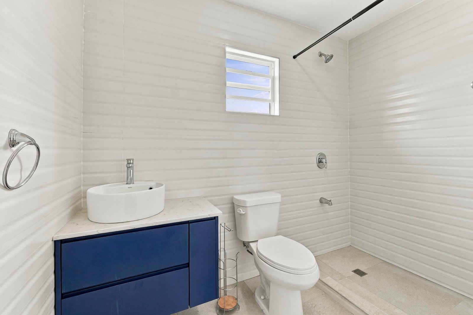 Coconut design, Lot 113: bathroom with a blue vanity, round basin and toilet.