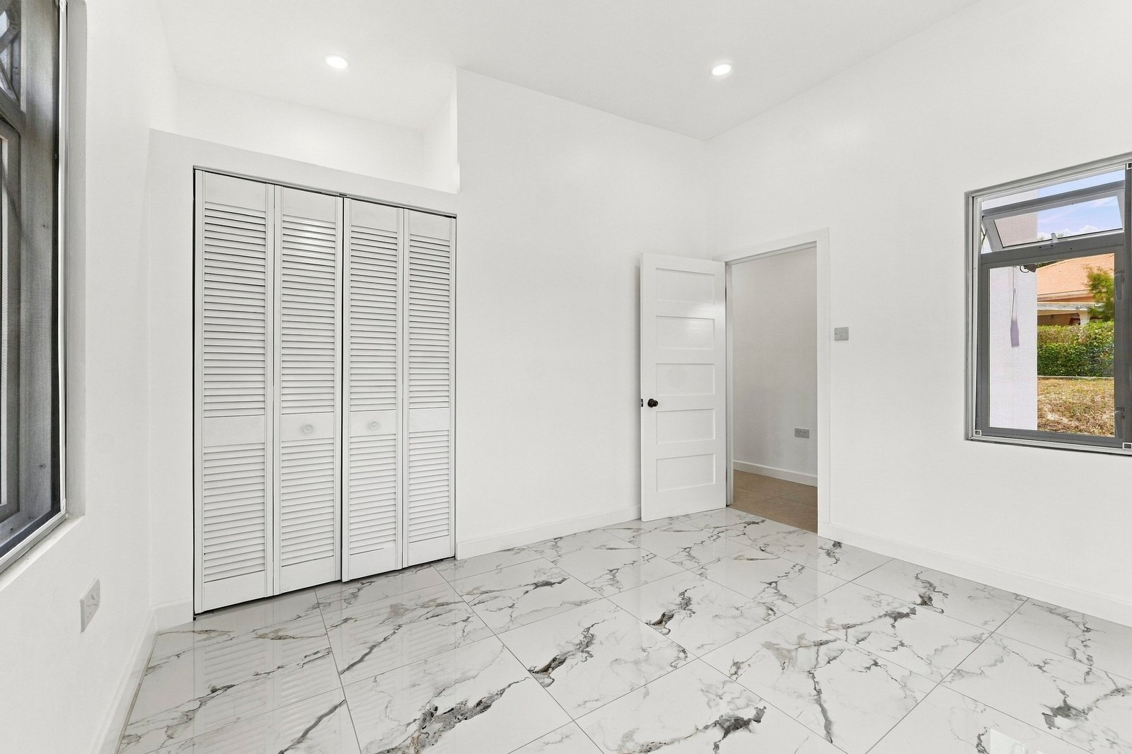 Hibiscus design, Lot 131: unfurnished room with windows on adjoining walls and built-in storage.