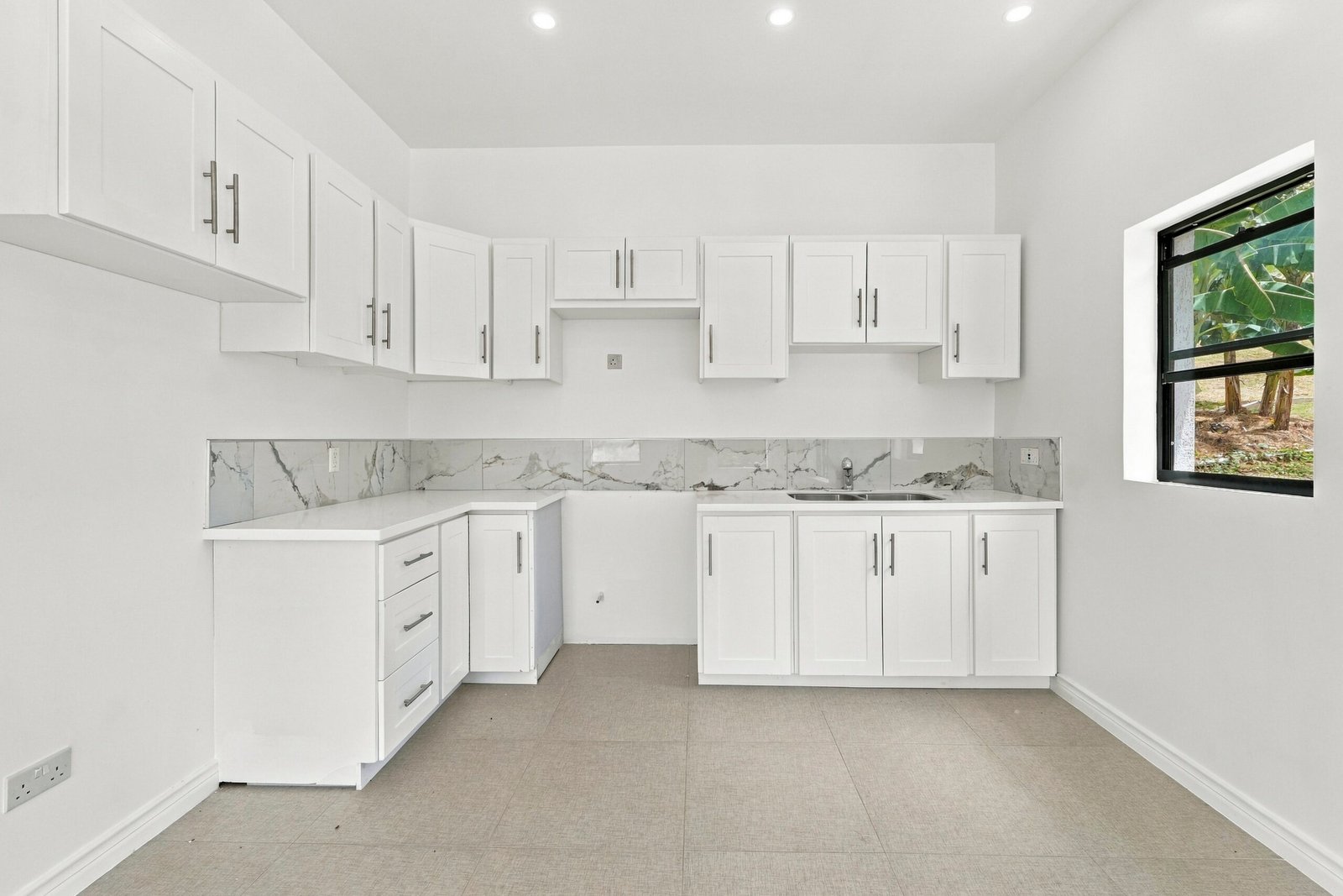Sapodilla design, Lot 122: white kitchen cabinets with tiled backsplash and corner countertop.